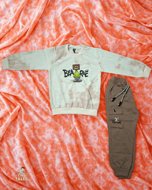 Beige sweatshirt with graphic design and brown pants on a pink tie-dye background