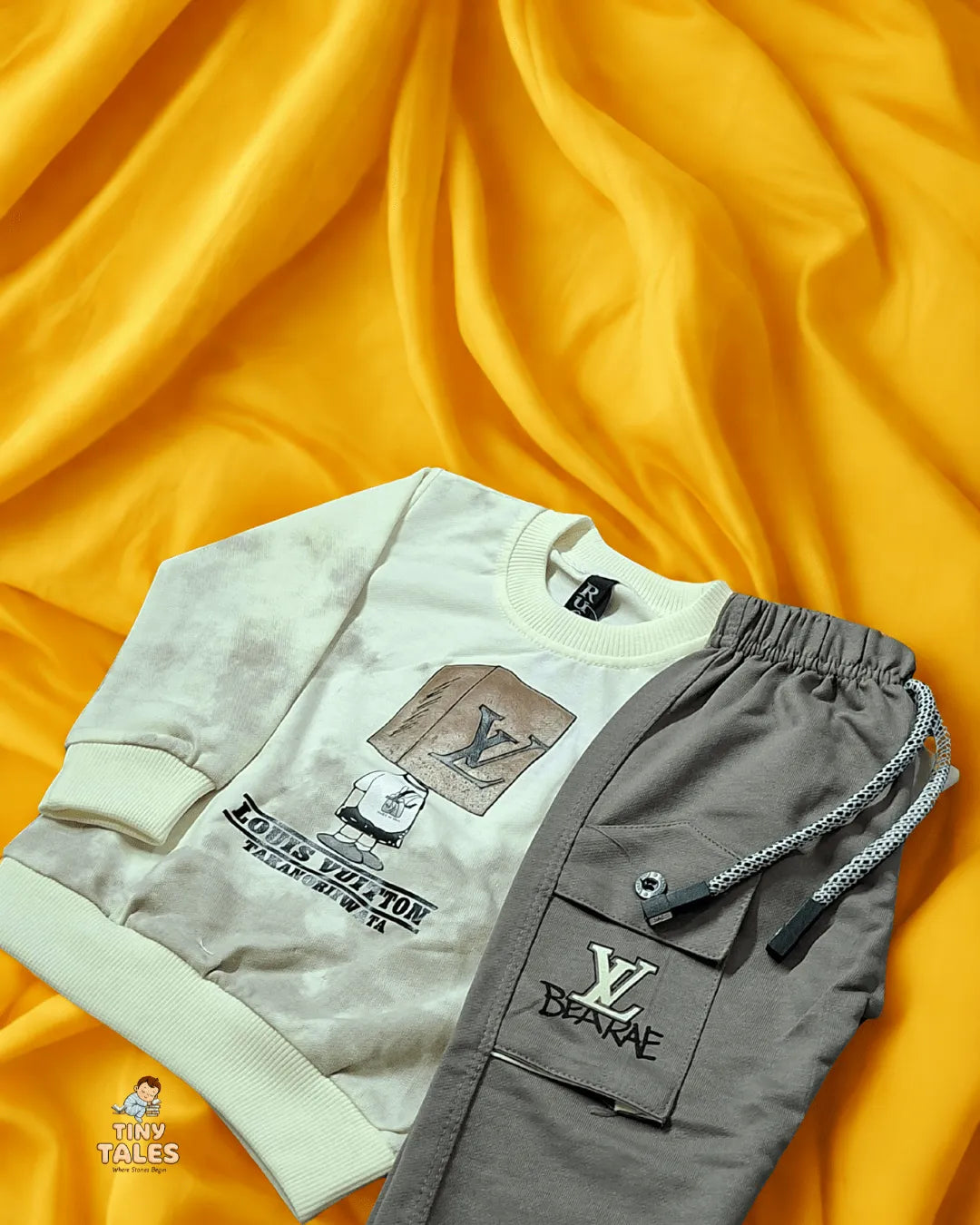 Gray sweatshirt and pants with brand logos on a yellow fabric background
