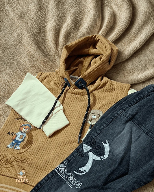 Brown hoodie with embroidered design on a beige fabric background