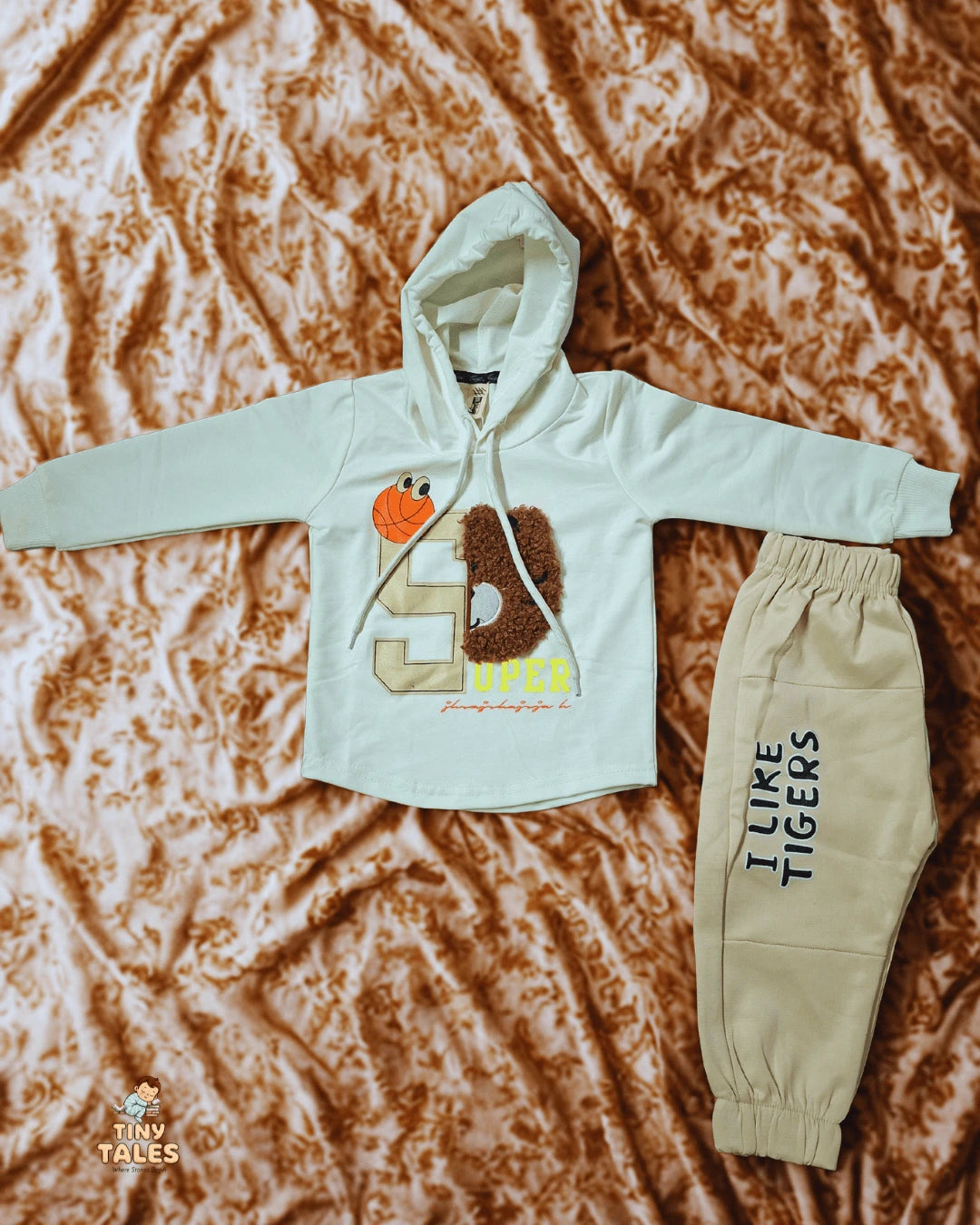 Children's hoodie and pants set with 'I Like Tigers' text on a textured brown background, Tiny Tales baby clothing, Organic baby clothes Pakistan, Premium baby wear, Soft cotton baby rompers, Newborn and toddler outfits, Baby dresses and essentials, Eco-friendly baby fashion, Cute baby clothes online, Safe baby clothing brand, Tiny Tales baby shop