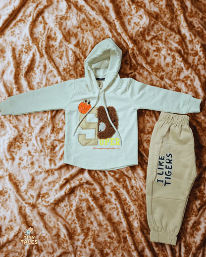 Children's hoodie and pants set with 'I Like Tigers' text on a textured brown background, Tiny Tales baby clothing, Organic baby clothes Pakistan, Premium baby wear, Soft cotton baby rompers, Newborn and toddler outfits, Baby dresses and essentials, Eco-friendly baby fashion, Cute baby clothes online, Safe baby clothing brand, Tiny Tales baby shop